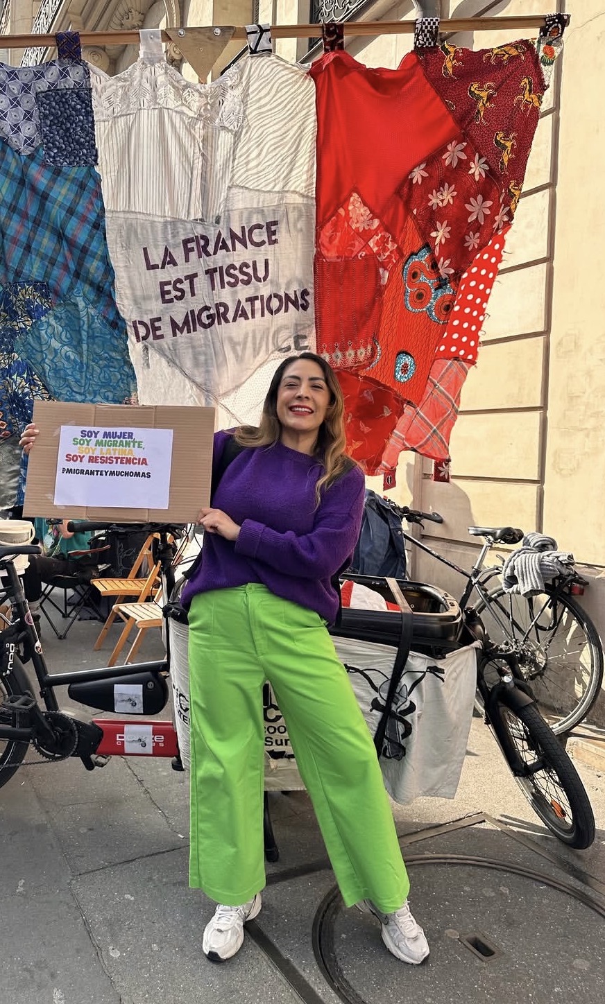 Mujer latina en una marcha sosteniendo un cartel en París